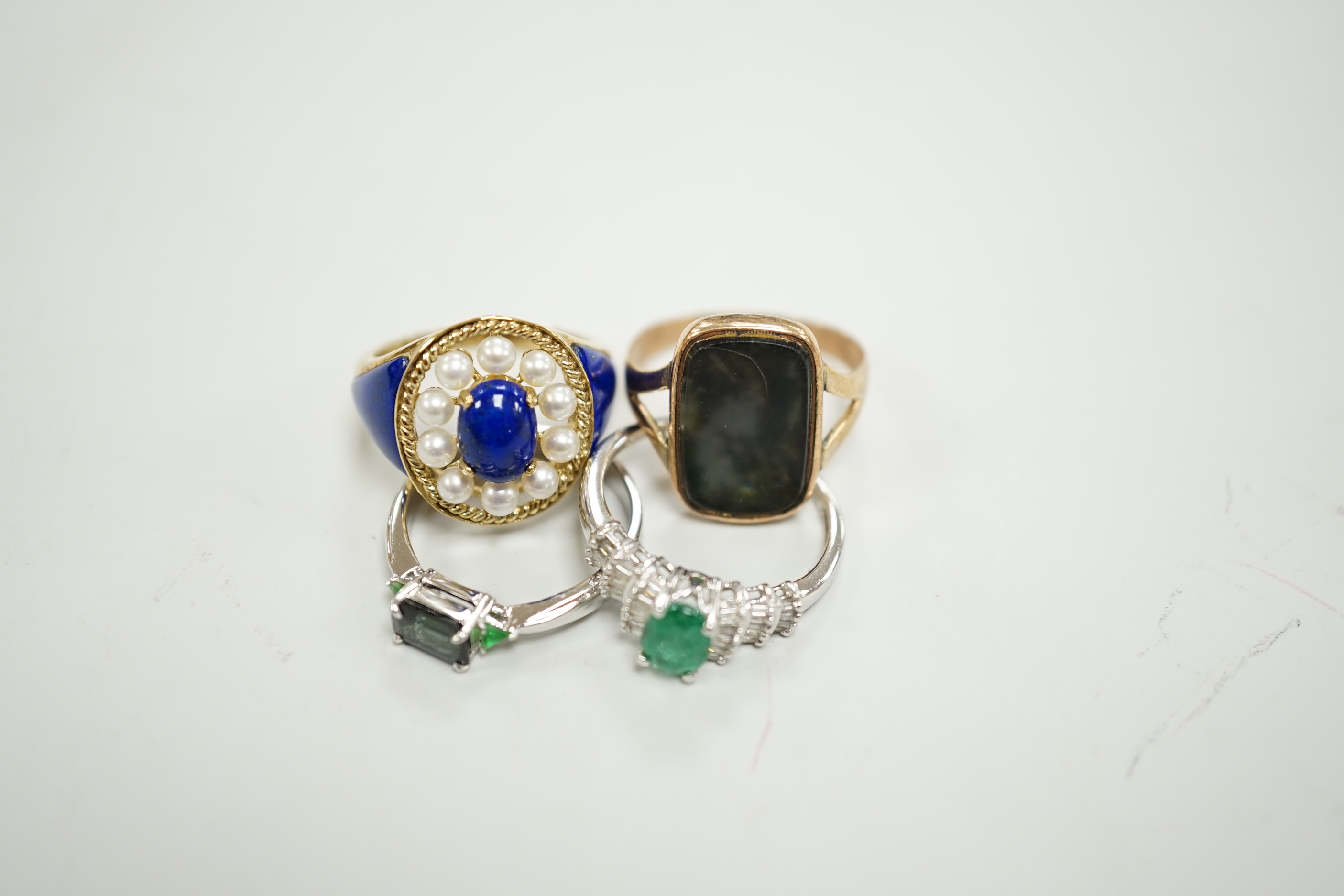 A modern 750 white metal and three stone gem set ring, two 9ct gold and gem set rings including lapis and seed pearl and one other yellow metal ring.